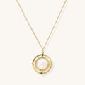 Gold-plated pendant necklace with circular orbital design, iridescent mother-of-pearl center and green zirconia accents