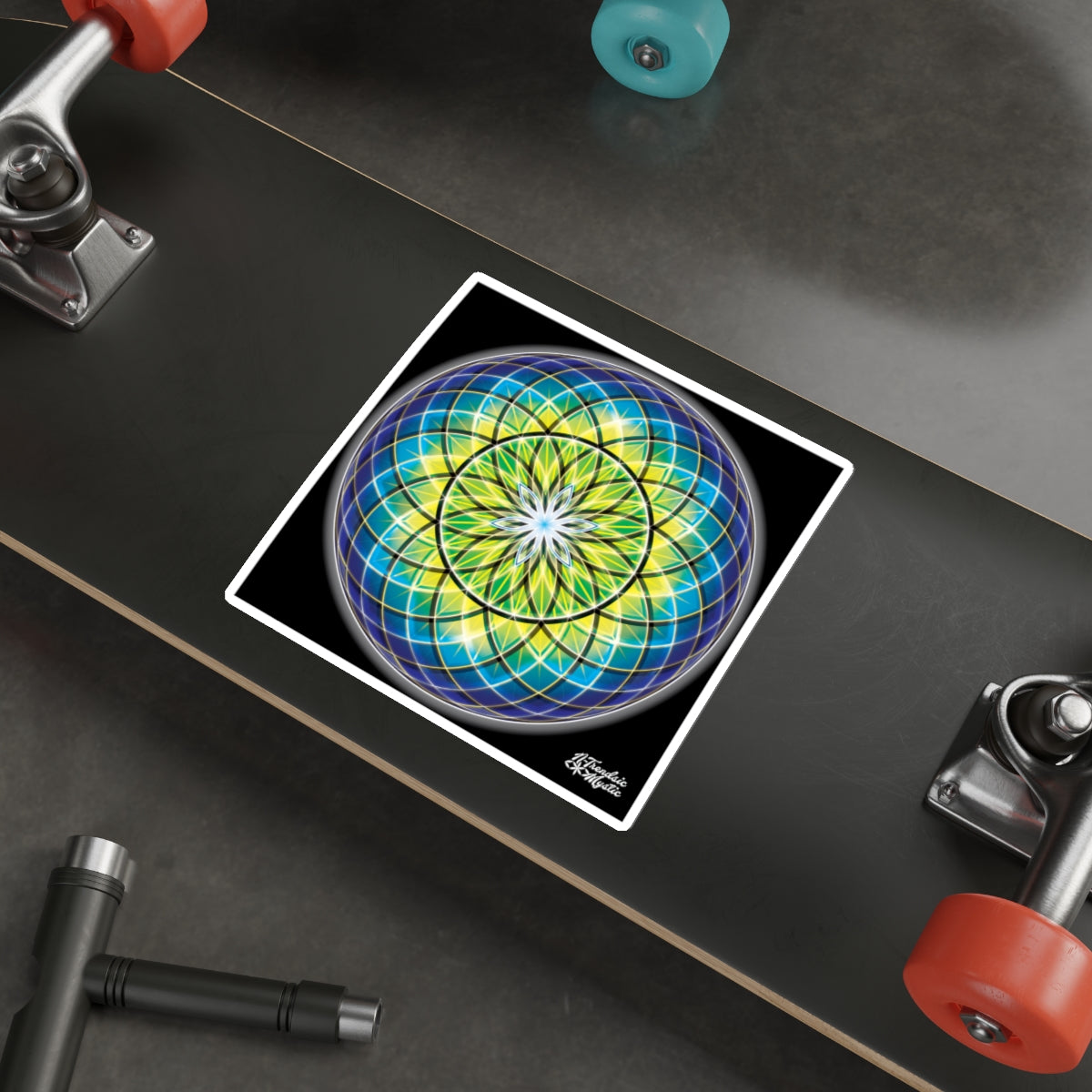 Colorful geometric design on a skateboard deck with visible trucks and wheels.