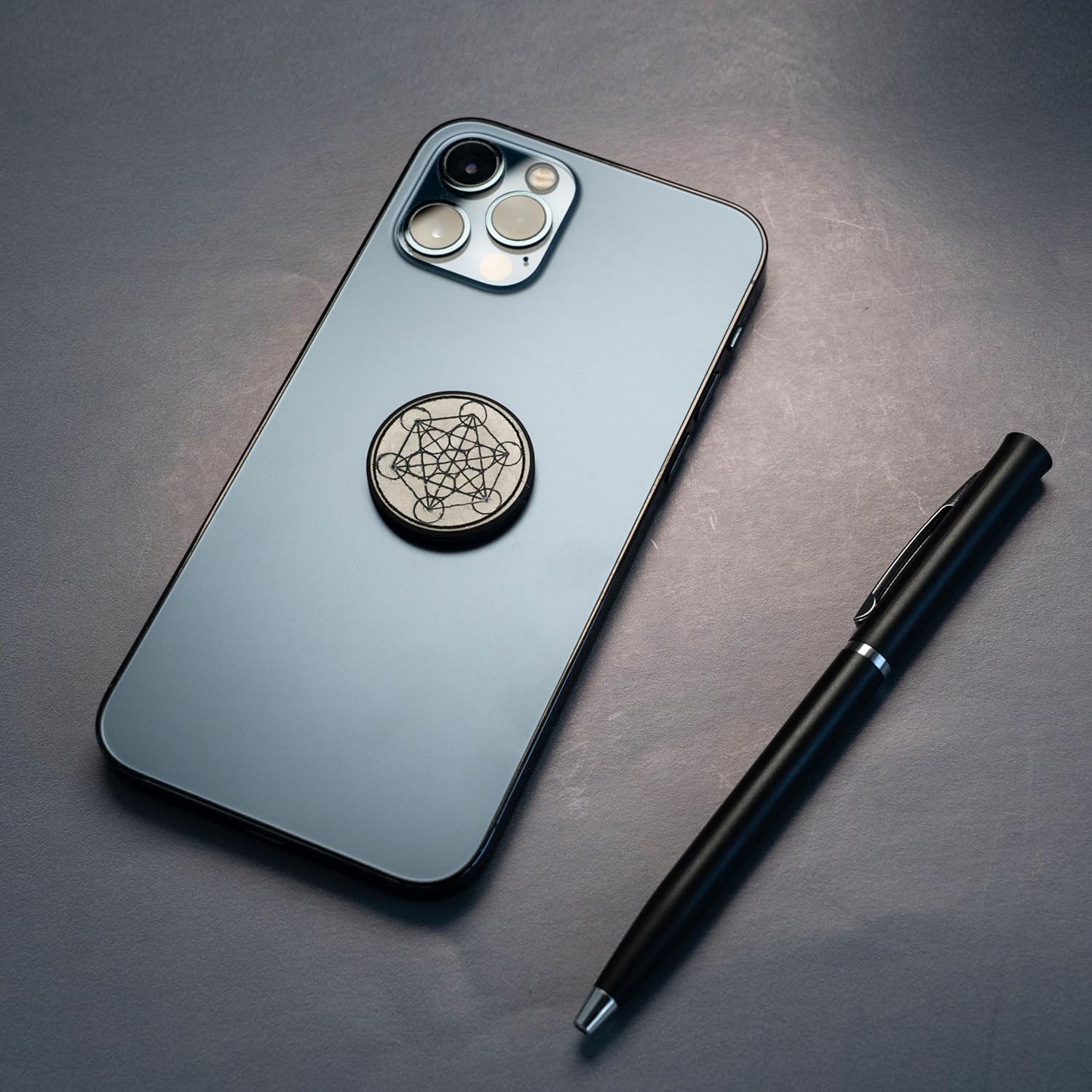 Shungite round phone sticker — polished stone with sacred geometry engravings (Merkaba, Metatron’s Cube, Flower of Life) or plain polished finish