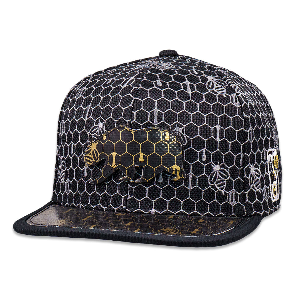 Black and white cap with honeycomb pattern and bee designs on a white background