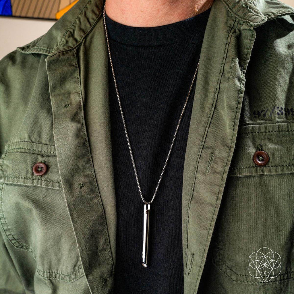 Person wearing a green jacket and black shirt with a necklace