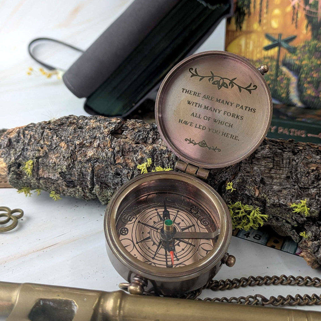 Bronze compass with engraved text on a natural background