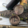Bronze compass with engraved text on a natural background