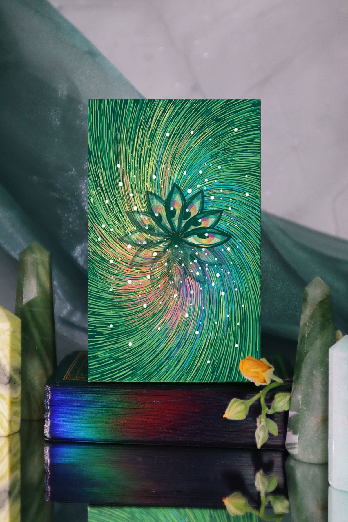 Decorative piece with a green abstract design and eye-like symbol on a reflective surface.