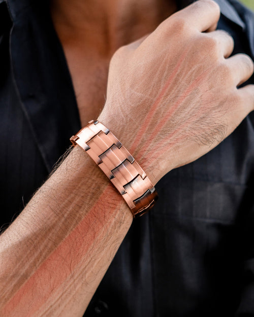 Copper bracelet on a wrist with a blurred background