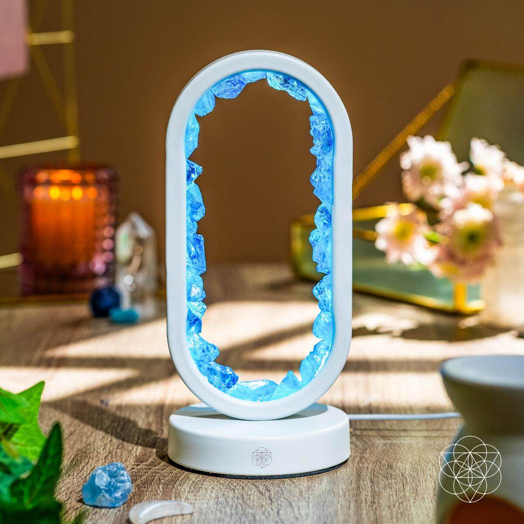 Decorative lamp with blue crystal-like design on a wooden surface.