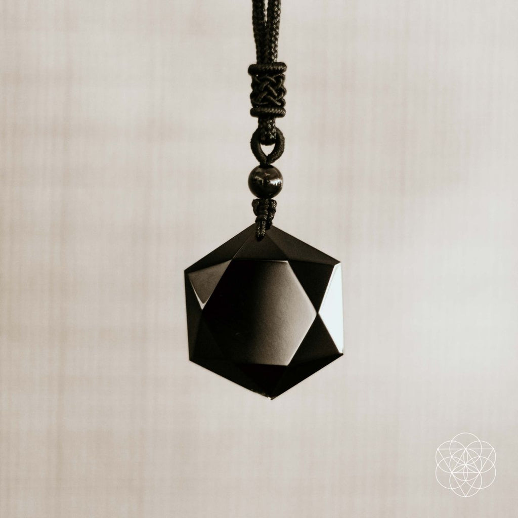 Black geometric pendant on a beige background