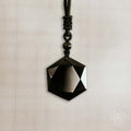 Black geometric pendant on a beige background