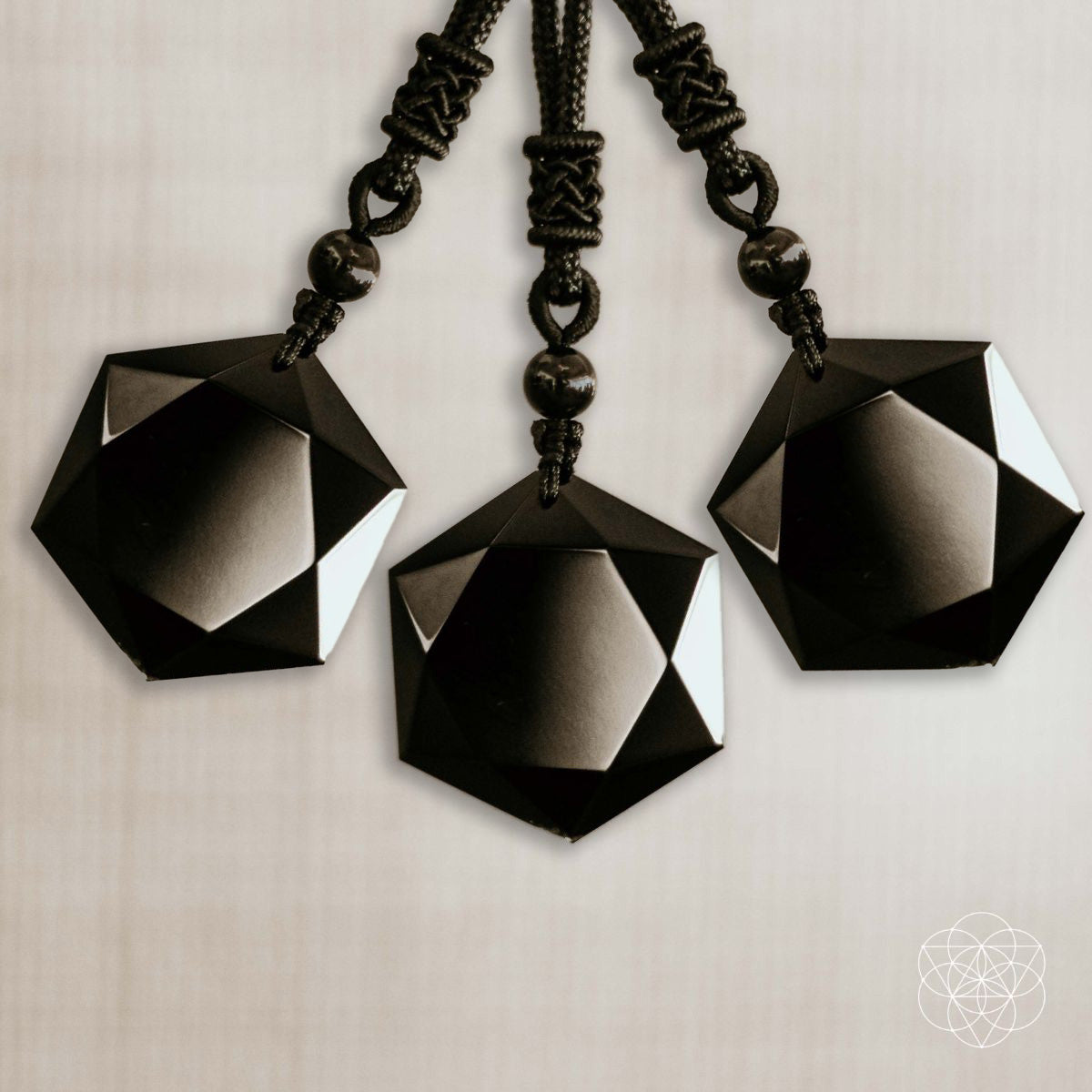 3 Black geometric pendant necklaces on a neutral background