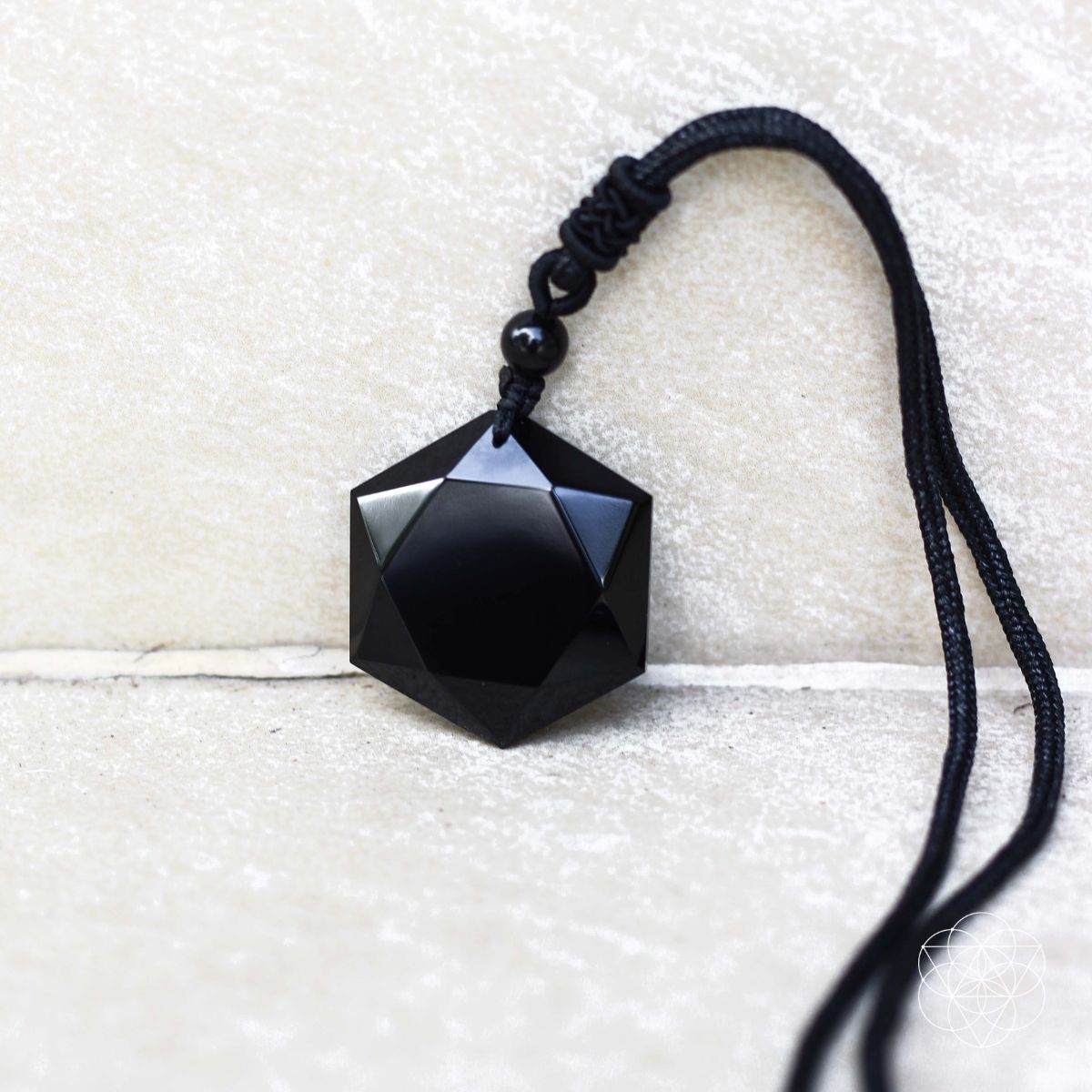 Hexagram pendant detail showcasing volcanic glass texture.