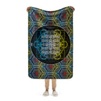 Person holding a colorful blanket with geometric patterns and text on a white background